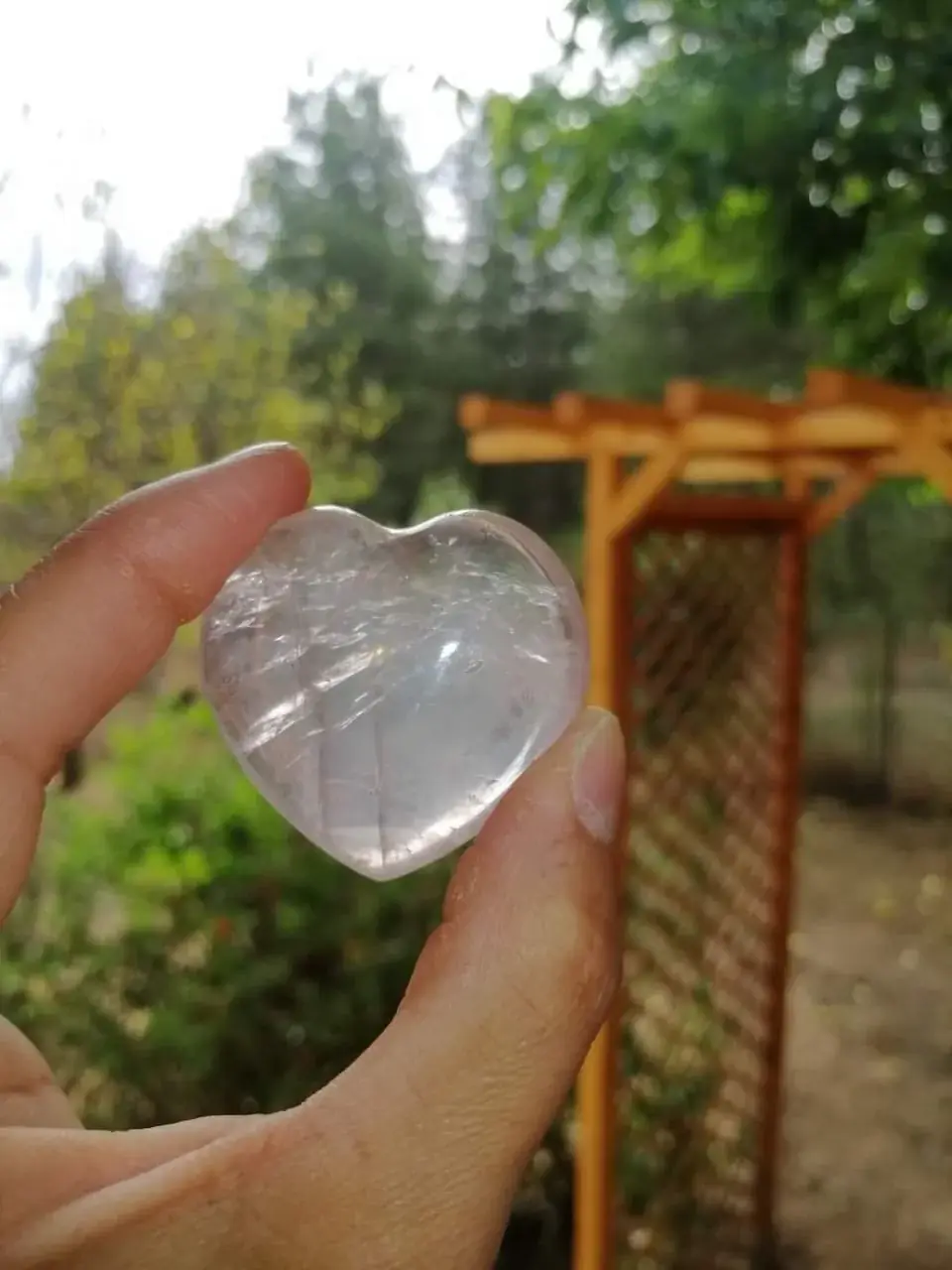 Un cœur de quartz rose tenu au creux de la main